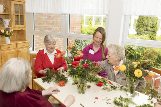 Eine Gruppe Seniorinnen steckt mit einer Pflegekraft Blumensträuße, Pflege in der Residenz, Stationäres Pflegeangebot, Wohnen und pflegerische Unterstützung in Hamburg-Volksdorf, Residenz am Wiesenkamp Eine Gruppe Seniorinnen steckt mit einer Pflegekraft Blumensträuße, Pflege in der Residenz, Stationäres Pflegeangebot, Wohnen und pflegerische Unterstützung in Hamburg-Volksdorf, Residenz am Wiesenkamp